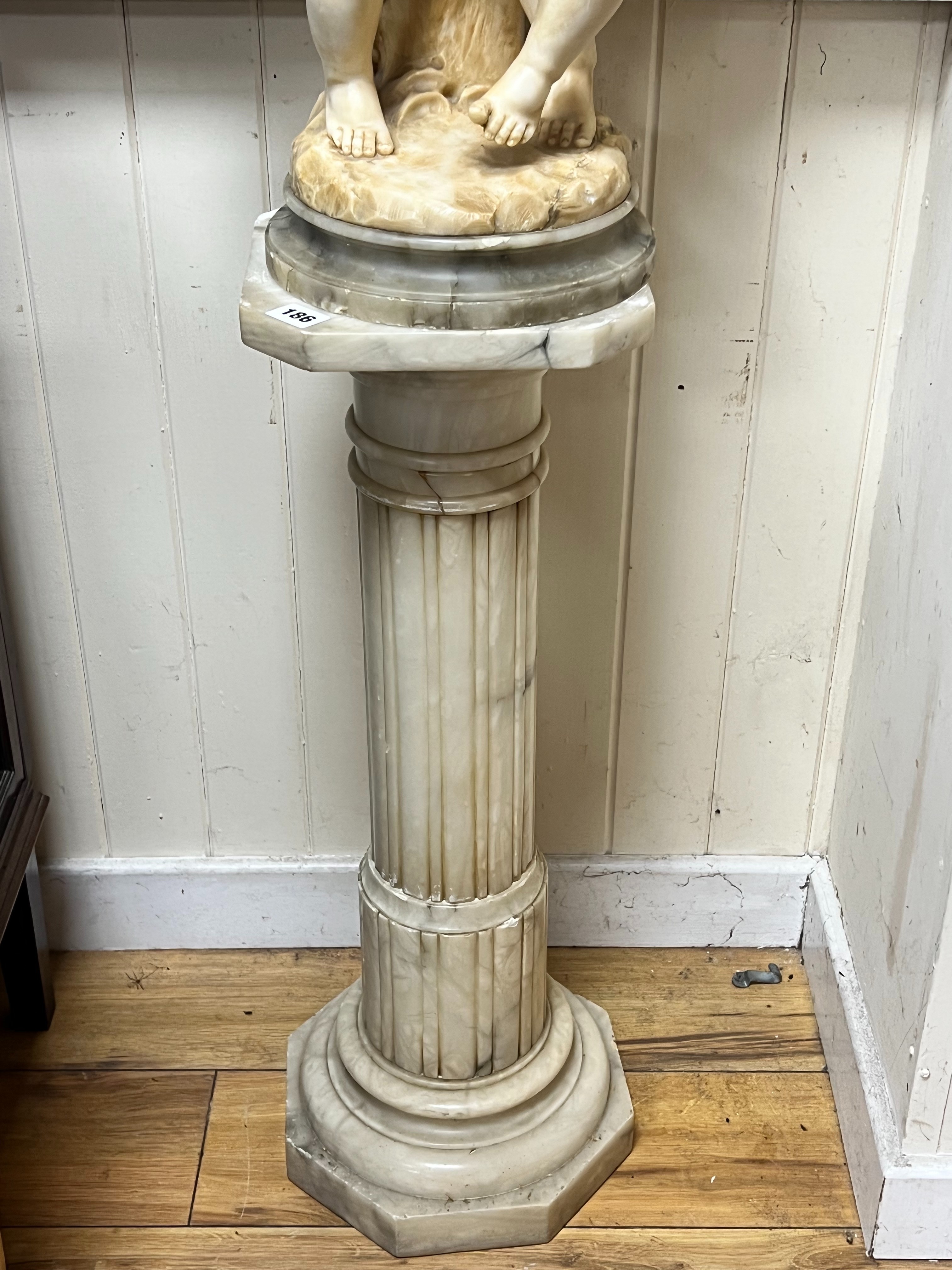 An Italian alabaster carving of bacchic cherubs on fluted pedestal, overall height 130cm